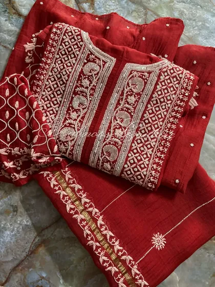 Another perspective of the folded Anarkali set, emphasizing the rich color and the density of the handwork on the yoke and sleeves.