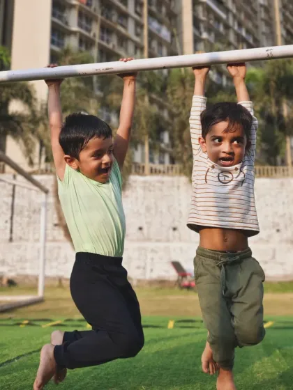 Two of our youngest warriors having fun while building grip strength on the pull-up bar. Play is the best way to learn.
