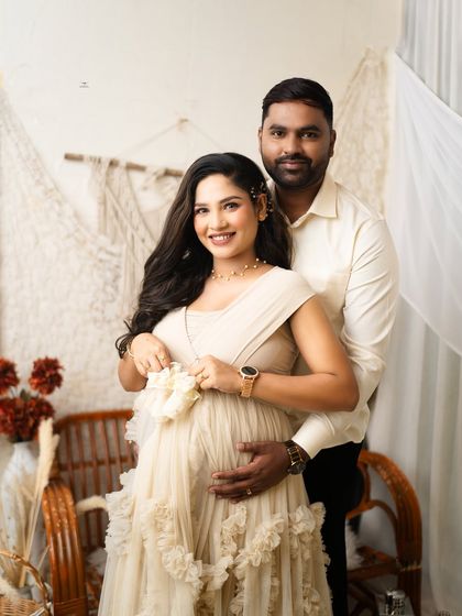 A sweet shot of the mother-to-be holding a pair of tiny baby shoes. This pose is a beautiful way to symbolize the little one who is on the way.
