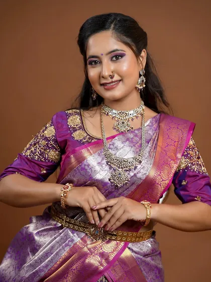 This bride chose a silver-finish Victorian set for her reception. It's a unique and elegant choice that pairs beautifully with her purple saree.