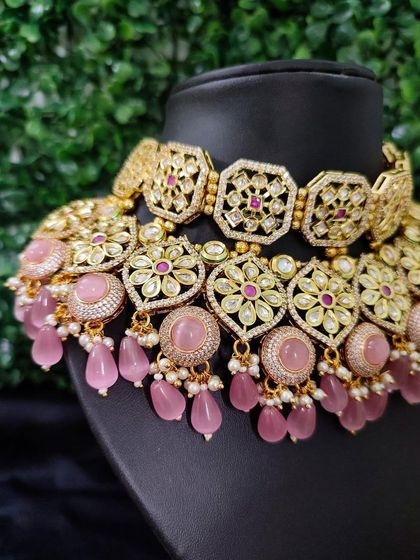 A close-up of the choker, highlighting the floral kundan motifs and the soft pink stone drops.