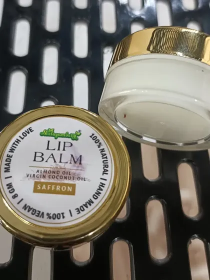The golden lid and clear jar of our Saffron Lip Balm. It's a small luxury for your daily lip care routine, made with the best natural ingredients.