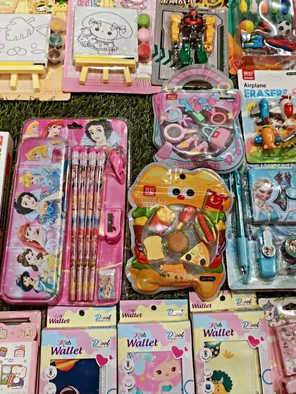 Here is a top-down view of my Kanjak return gift collection. You can see the variety I offer, from Disney Princess stationery sets and wallets to fun, food-themed erasers and small toys.