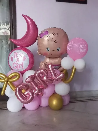 I create sweet and memorable balloon arrangements for baby announcements. This "It's a Girl" bouquet features a baby-shaped foil balloon, a crescent moon, and custom lettering in a pink, white, and gold color scheme.