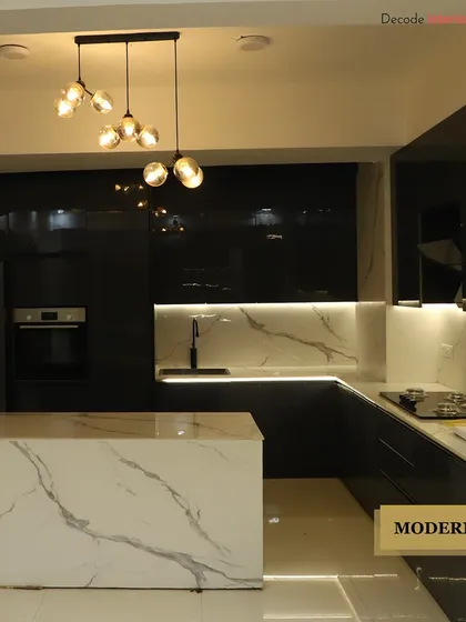 We love the dramatic contrast in this modern kitchen. The design combines high-gloss black cabinetry with a white marble island and backsplash, illuminated by statement pendant lighting to create a space that is both functional and luxurious.