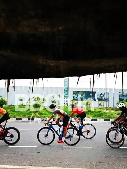 The elite peloton, framed by the darkness of an underpass, creates a dramatic shot.