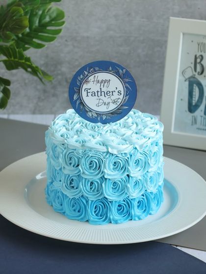 A beautiful blue rosette cake with a "Happy Father's Day" topper, an elegant choice to celebrate your dad.