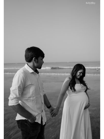 A classic black and white shot of the couple walking by the sea, hand in hand, stepping into their future as a family.