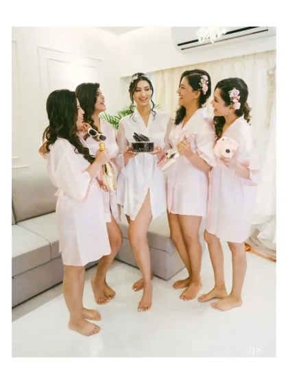 The bride and her bridesmaids, dressed in matching pink robes, sharing a joyful moment. This shot is full of fun, friendship, and pre-wedding excitement.