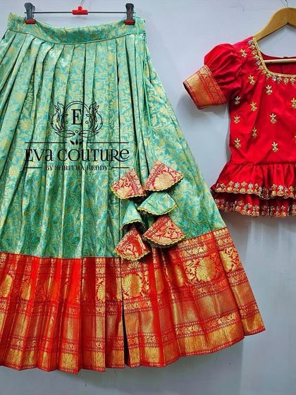 A deconstructed view of a red and green Banarasi lehenga, showing the tiered peplum blouse and the rich brocade skirt.