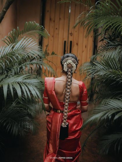A beautiful shot of the back of the bride, showcasing her elaborate traditional hairstyle with a long braid and flowers.