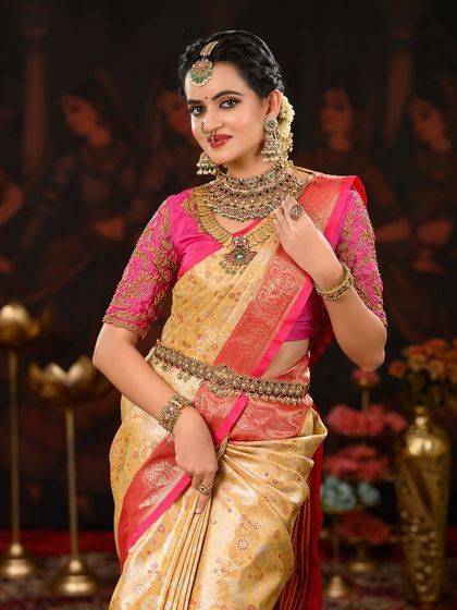 This portrait highlights the beautiful contrast between the pink blouse and the gold saree, with makeup tones chosen to match perfectly.