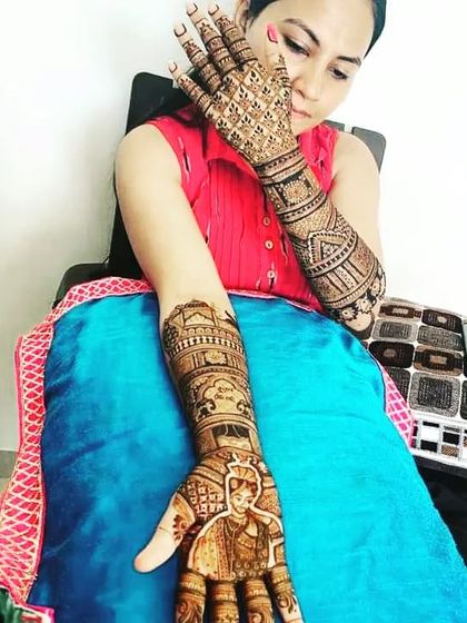 A bride posing with her custom groom-portrait mehndi. I can create designs where each hand has a different story to tell.