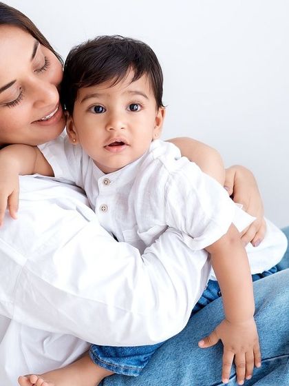 A mother cuddling her son. The simple setting with jeans and a white shirt feels so natural and real.
