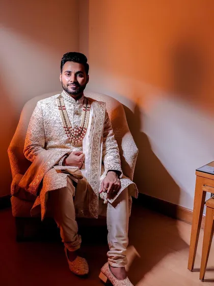 A portrait of the groom in his elegant sherwani, seated with a confident and calm demeanor before the main event.
