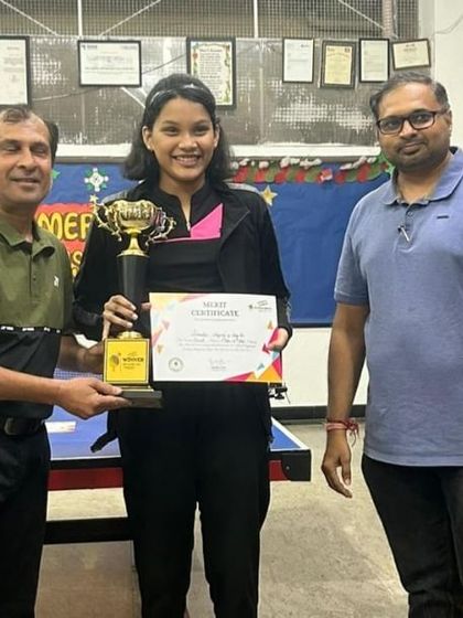 Our female champion shines with her trophy. We are committed to developing strong and skilled female players in the competitive table tennis circuit.