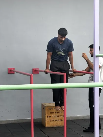Here, a coach provides subtle cues to help a member maintain proper form during a dip hold. It's these small adjustments that make a huge difference in building strength and preventing bad habits.