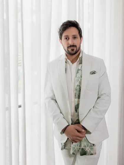 A dapper portrait of the groom, looking sharp in his white suit.