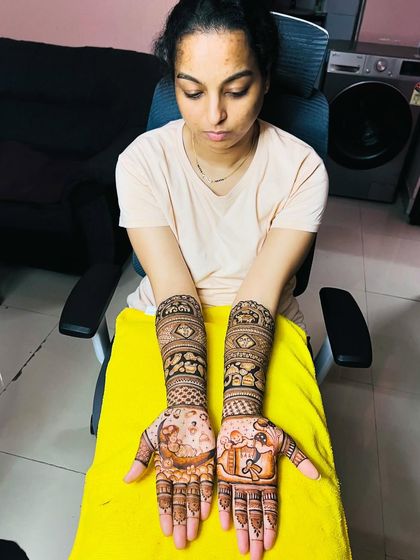 A clear view of the full baby shower mehndi design, extending up both arms with beautiful, consistent patterns.