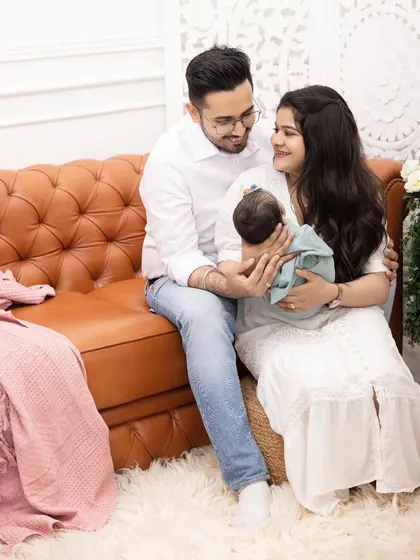 A classic family lifestyle session on our comfortable leather sofa. The parents look on lovingly as they hold their newborn, creating a timeless and relaxed family portrait.