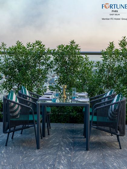 A table for four, perfectly set against a backdrop of greenery on our rooftop terrace. Ideal for small groups and family outings.