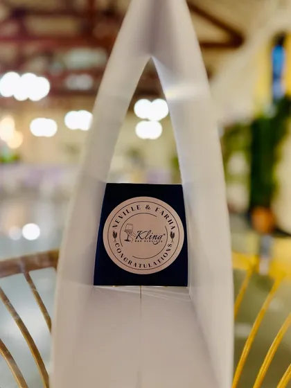 A custom sticker congratulating "Neville & Fariha" on a chair back. We think beyond the bar to help you personalize your entire event space.