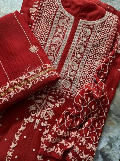 A close-up view of the folded ensemble, focusing on the sleeve and dupatta border details.