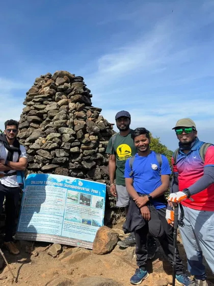 Another proud group at the Pushpagiri peak sign. Using trekking poles, as seen here, is highly recommended for this difficult climb.