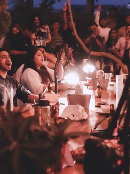 A beautiful, dimly lit shot of the audience completely captivated by the music, singing along with hands in the air.