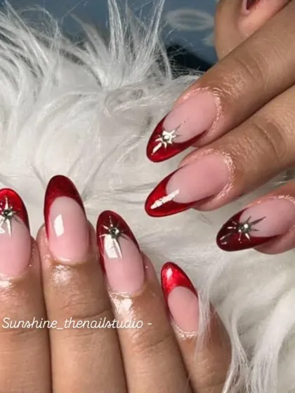 A close-up of the chrome star detail on the red jelly French nails.