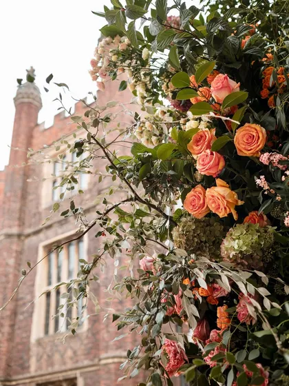A close-up of the lush, garden-style flowers against the historic brickwork of the palace. The contrast of textures and colors is a key part of our design philosophy.