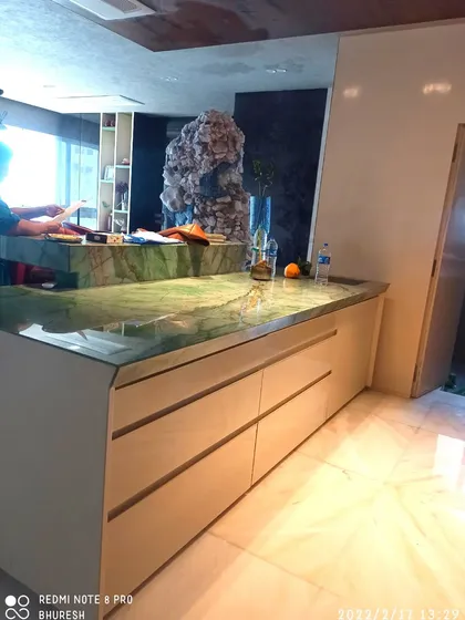 A view of the stunning green marble island countertop in the Jhamdar residence. The island provides extra workspace and storage with its deep, handleless drawers.