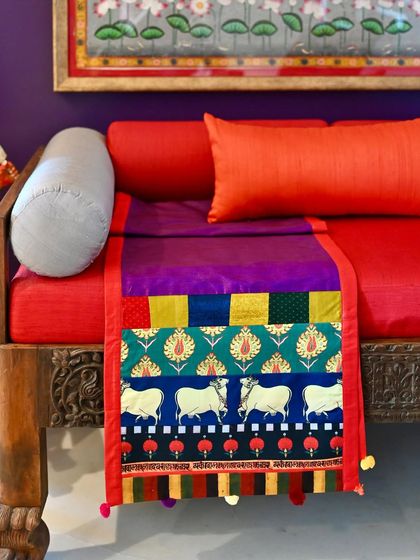 A one-of-a-kind reversible silk runner, custom-made with a patchwork of vibrant fabrics including a Pichwai-inspired cow print.