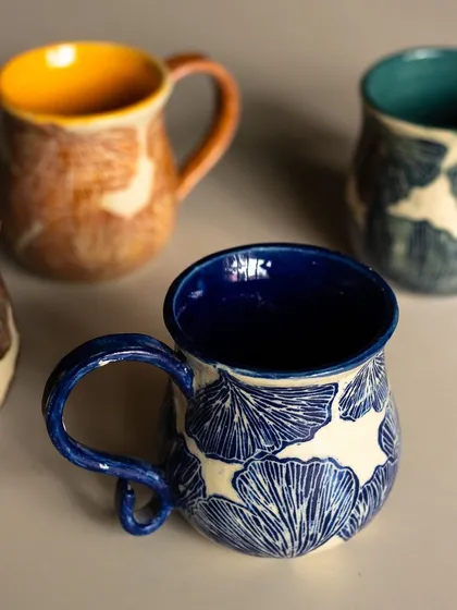 We’re obsessed with Sgraffito, and this mug shows why. We paint on a layer of color and then carve away to reveal the design underneath. This floral pattern is a student favorite.