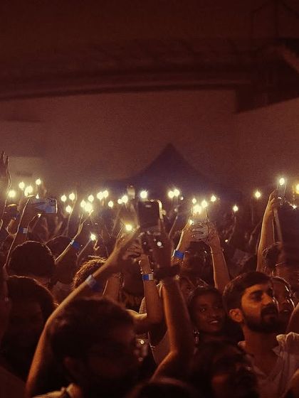 A sea of phone lights illuminates the crowd at the White Party. This iconic shot shows the deep engagement and appreciation of the audience.