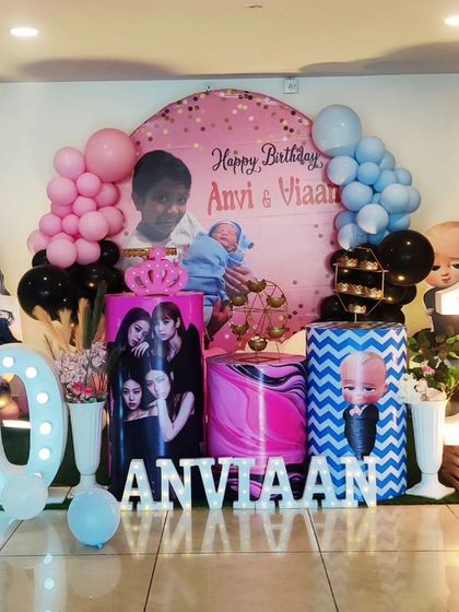 A joint 10th and 1st birthday celebration with a K-Pop and Boss Baby theme. The decor features a Blackpink cutout, a Boss Baby plinth, and large light-up numbers.
