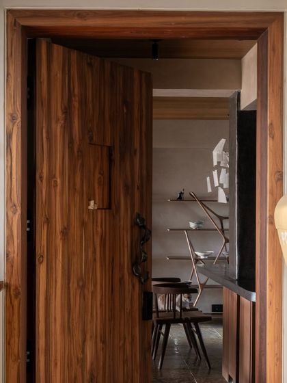 Wood is a unifying element throughout the home, seen here in the custom-designed door. Its consistent presence connects different zones and infuses the space with a warm, lived-in aesthetic.