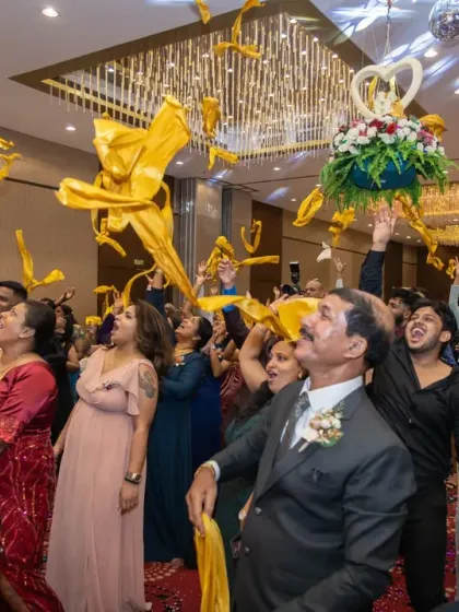 The bouquet and garter toss is always a moment of fun and anticipation. Here, guests reach for the flying streamers, creating a dynamic and colorful action shot during the reception.
