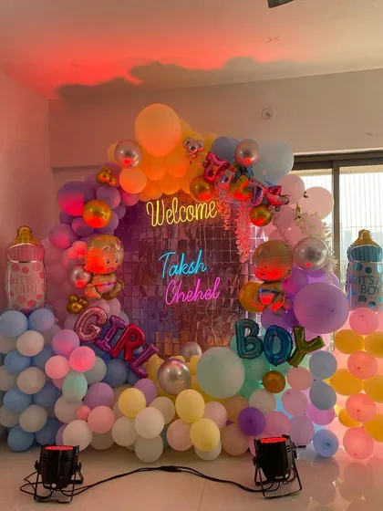 A grand "Welcome" decoration for twins, Taksh and Chehel. The setup includes a large balloon ring, neon signs, and "Boy" and "Girl" foil balloons.