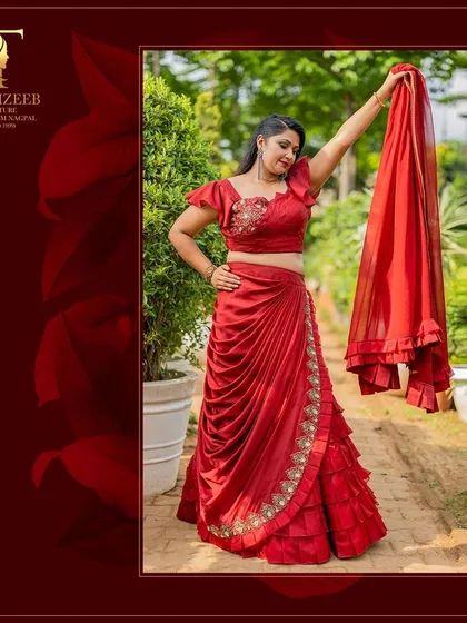 A beautiful shot of our red draped saree, perfect for Karwa Chauth. The ruffled details and embroidered blouse make it a truly special piece.