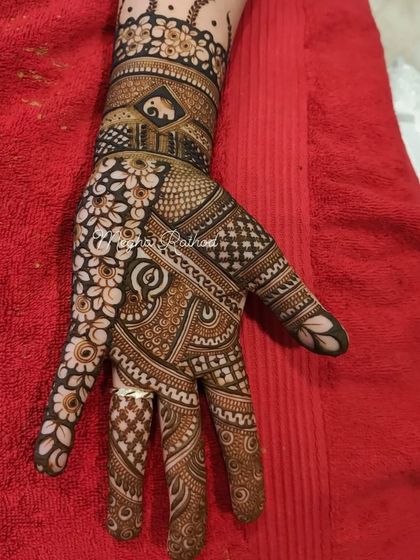 A complex design featuring a small elephant motif on the wristband, surrounded by a dense mix of floral and geometric patterns.