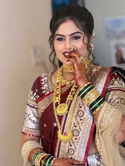 A happy bride showing off her complete look. The Maharashtrian nath and the intricate details of her jewellery are the highlights here.
