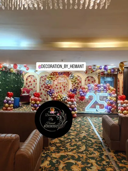 For a grand 25th wedding anniversary, I transformed this hall into a spectacular celebration space. The setup includes a large stage with multiple arches, a custom ring backdrop, and a lit marquee number, all tied together with a vibrant balloon arrangement.