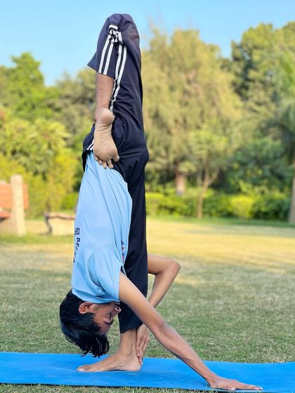 Balance is something you create. A student works on a challenging one-legged forward bend during our park session.