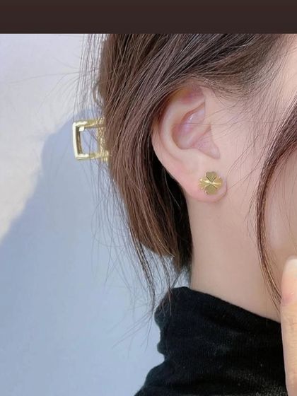 A styled shot of the four-leaf clover stud earrings. Their simple and elegant design makes them a versatile accessory for any look.