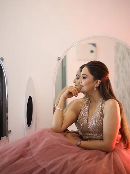 A reflective moment. The soft lighting enhances the glow of her skin and the shimmer on her eyelids.