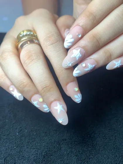 A dreamy, celestial-themed set with a nude base, white 3D stars, and small iridescent crystal accents.
