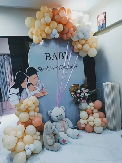 A personalized baby shower setup featuring a custom cutout of the family. This is a wonderful way to add a personal touch, complemented by teddy bears and a soft-colored balloon arrangement.