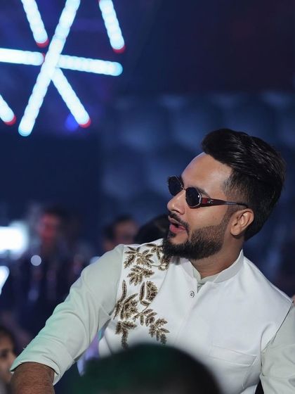 A candid shot of our client enjoying an event in his custom Indo-Western outfit. The detailed embroidery on the jacket adds a touch of elegance to his look.