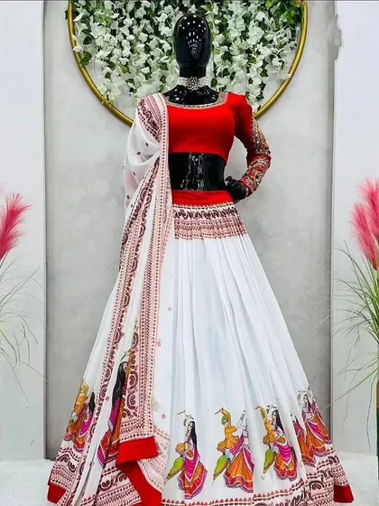 A beautiful white and red georgette chaniya choli. The border of the skirt features printed figures of dancers, adding a playful touch to this Navratri special outfit. It comes with a simple red blouse and a matching white dupatta.